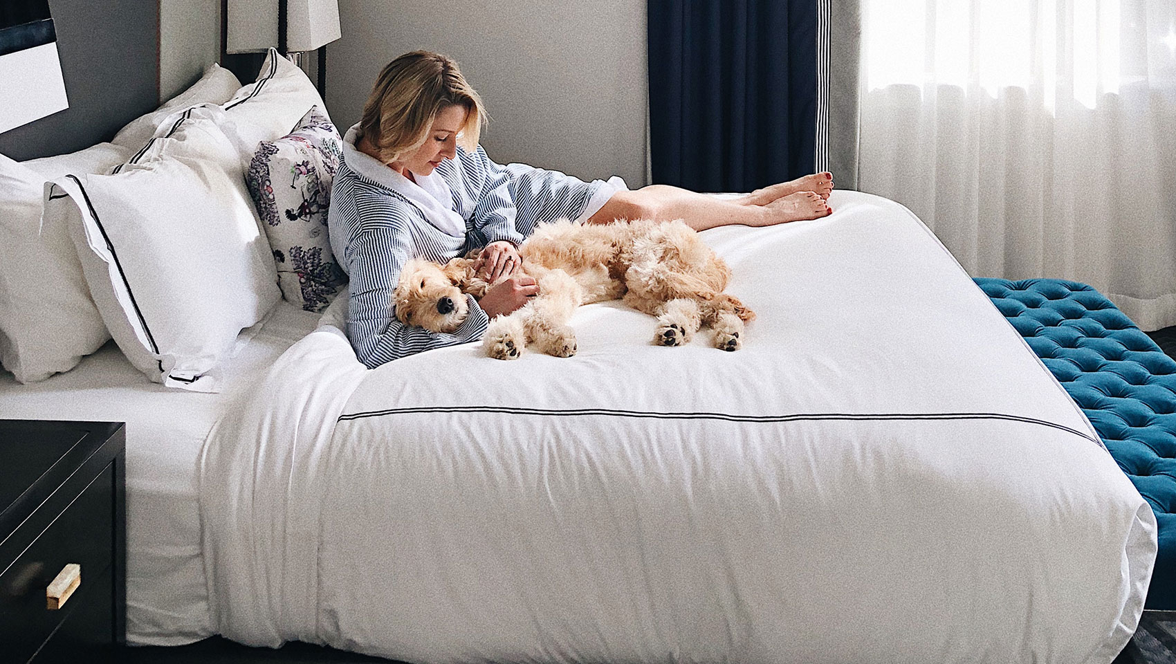 guest on cardinal king bed with dog